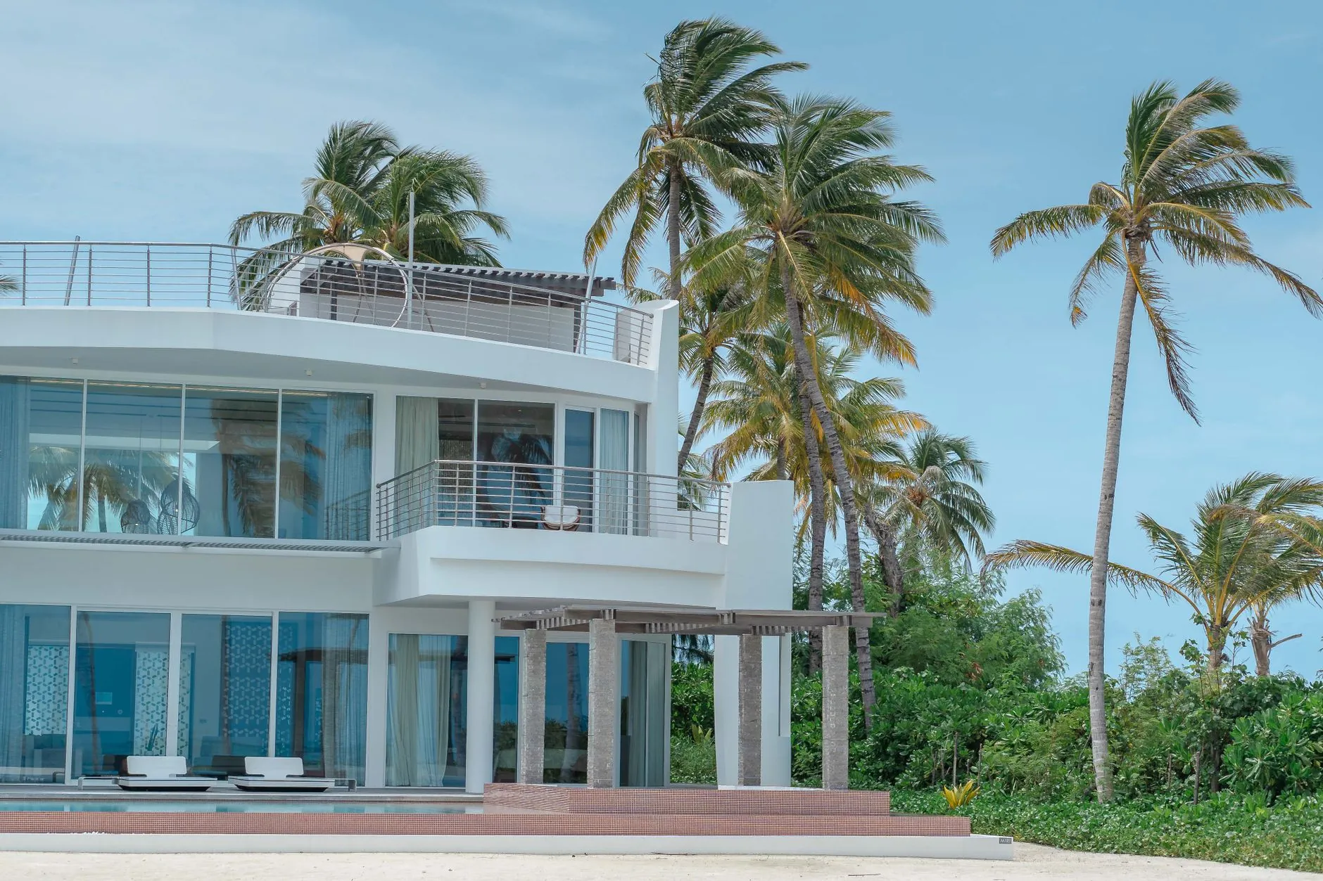 Prédio residencial de frente para o mar com palmeiras, imagem ilustrativa